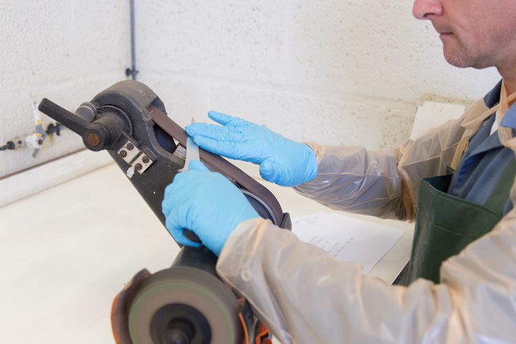 Staff member sharpening a knive.