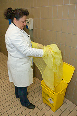 Remove the clean disposable apron slipped on in the clinic of origin