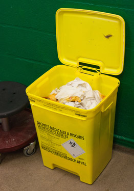 Almost filled yellow bin in examination room.